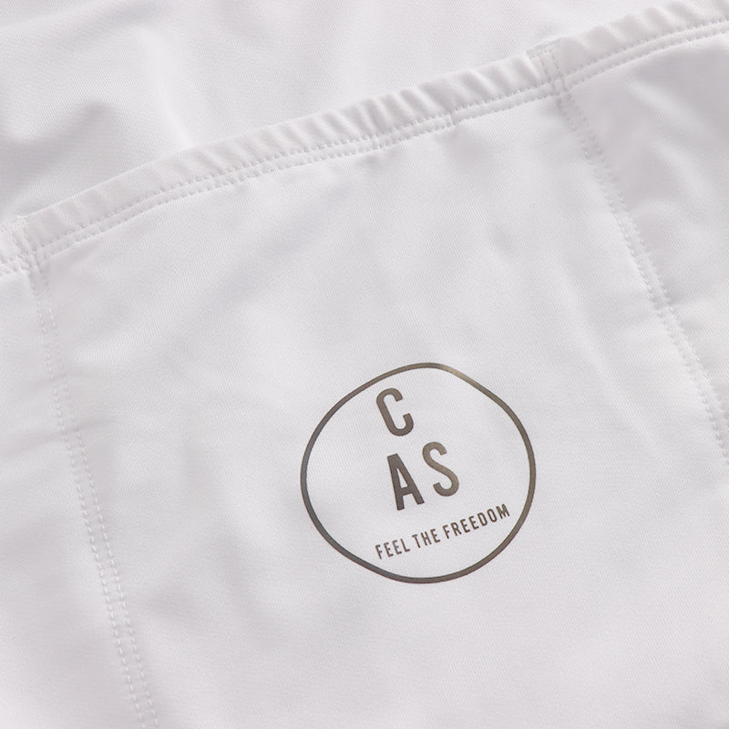 Rear pocket of men's white cycling long sleeve thermal jersey. CAS Feel the Freedom circular reflective logo.